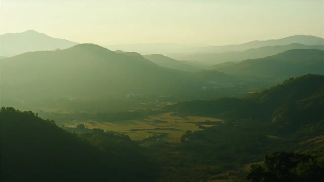 Chave de sítio em mãos, com paisagem rural desfocada ao fundo, símbolo de conquista de imóvel rural